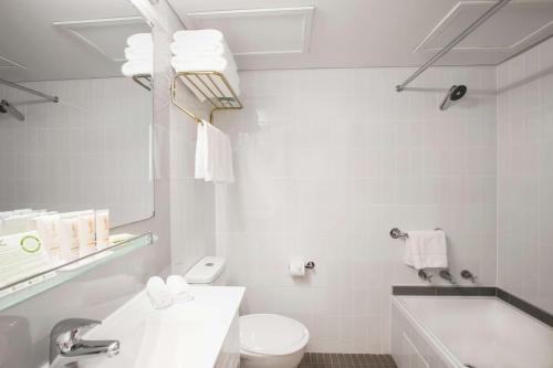 悉尼悉尼中央新城马洛酒店的浴室配有卫生间、盥洗盆和浴缸。