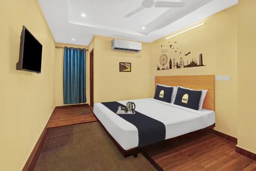 卡基纳达Super Capital O De Alphabet Kakinada的一间卧室配有一张大床和一台平面电视