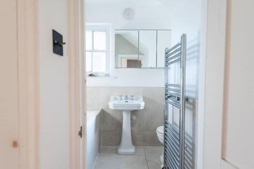 伦敦Stunning Flat in Highbury Hill的白色的浴室设有水槽和镜子
