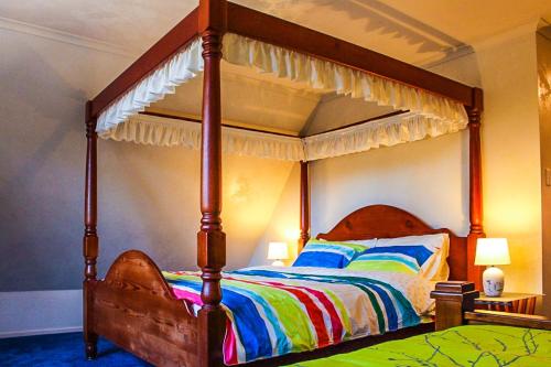 温特沃斯瀑布The Manor in Blue Mountains的一间卧室配有一张带天蓬的大床