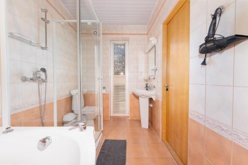 奥泰佩VäeVilla的带淋浴、盥洗盆和浴缸的浴室
