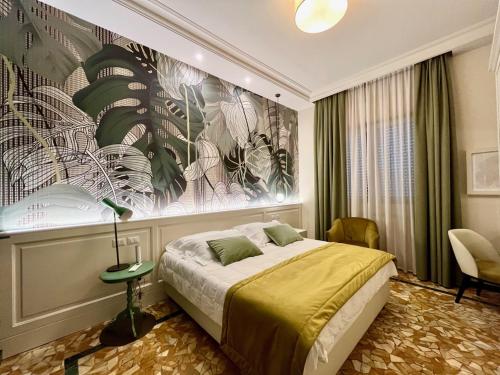 马尔米堡贝隆达酒店的卧室配有一张床,墙上挂着一幅大画