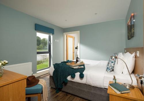 恩尼斯基林基里赫文湖滨小屋酒店的一间卧室配有一张床、一张书桌和一个窗户。