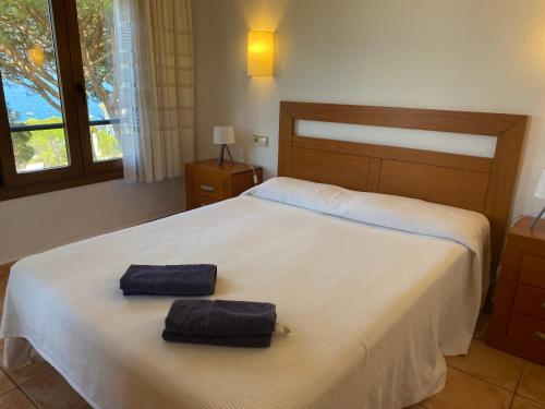 卡莱利亚德帕拉弗鲁赫尔Apartamento con espectaculares vistas al Mediterráneo的一间卧室配有一张床,上面有两条毛巾