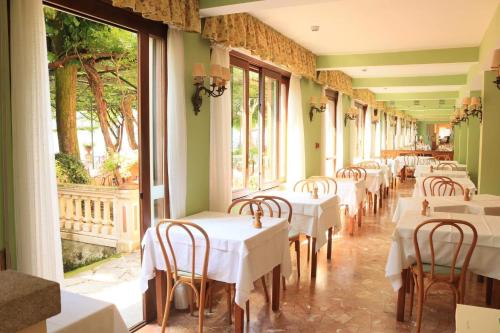 瓦尔索达斯特拉'意大利酒店的餐厅的一排桌子,有白色桌布