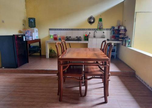 马格朗Anindya House的厨房里配有一张木桌和椅子