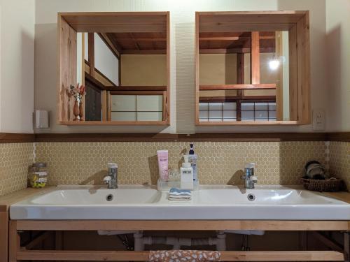 高山Guesthouse Tomaru的浴室设有2个水槽和2面镜子