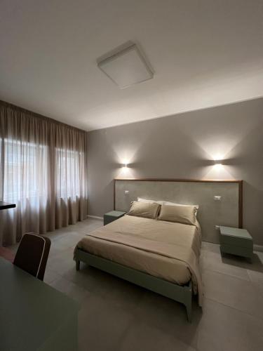 塔兰托Stanze d’Autore的一间卧室设有一张大床和一个窗户。