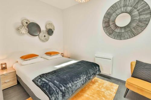Domaine Grand Piquecaillou - L'appartement Loupiac的一间卧室配有一张床、镜子和椅子
