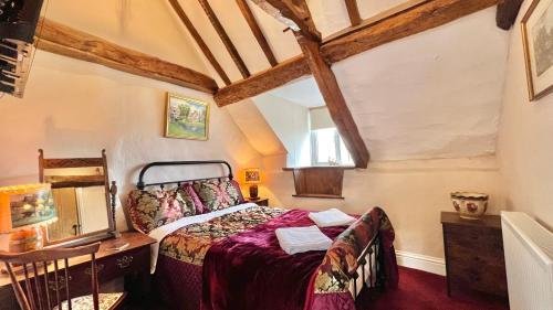 惠灵顿Cosy Cottage的一间卧室配有一张床、一张桌子和一个窗户。