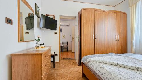 布罗托尼贾Apartment Alba的一间卧室配有一张床和一个带电视的梳妆台