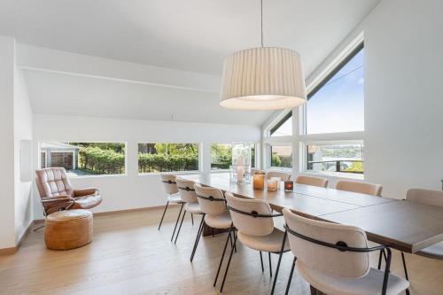 海宁格松Exclusive Family Villa in Haugesund - Lovely Ocean View, 5 Bedroom, Free parking的一间带长桌和椅子的用餐室