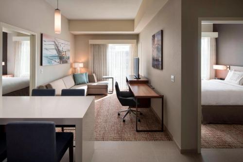 费尔菲尔德Residence Inn by Marriott Fairfield Napa的酒店客房带一张床铺、一张书桌和一间卧室