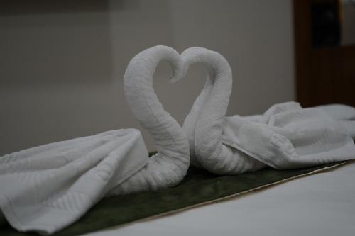 KevadiaHOTEL STATURE INN的床上的两条天鹅形状的毛巾