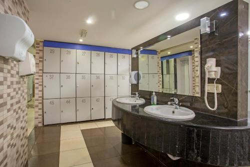 安曼Sadeen Amman Hotel的一间带两个盥洗盆和大镜子的浴室