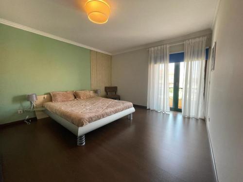 MarinhasMoradia praia de Esposende的一间卧室设有一张床和绿色的墙壁