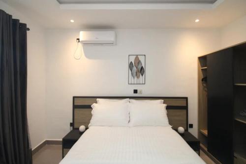 杜阿拉VOAK Home的一间卧室配有一张带白色床单的大床