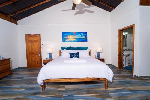 尼格瑞尔Blue Skies Beach Resort的一间卧室配有一张大床和吊扇