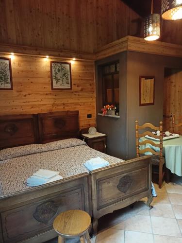 Bobbio PelliceL'Alpina Affittacamere的木制客房内的一间卧室,配有一张床