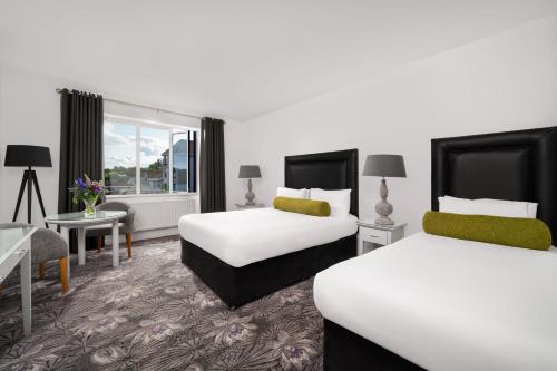 韦克斯福德斐里卡里格酒店的酒店客房设有两张床和一张桌子。