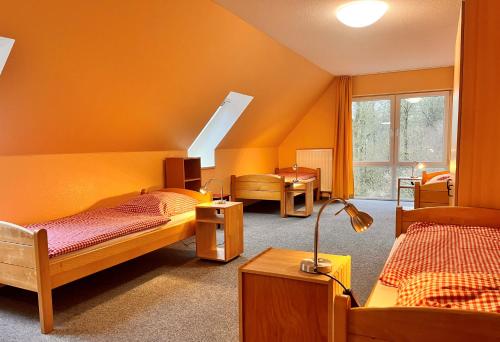 胡苏姆Nordsee Jugendheim Delphin的一间房间,带三张床和一盏灯