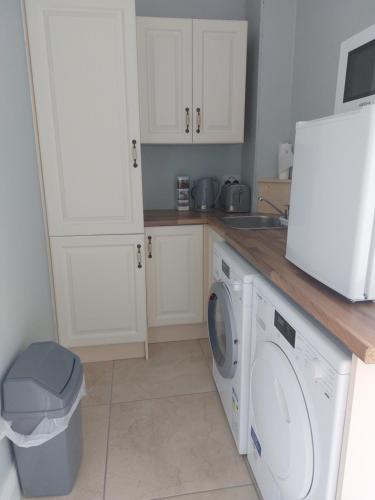 恩尼斯克朗Grá na Farraige的厨房配有洗衣机和水槽