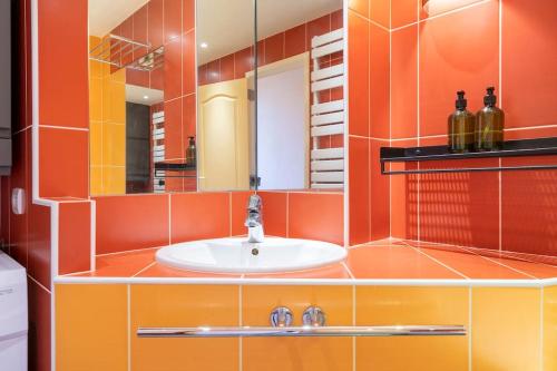 勒布尔热City Escape的浴室设有橙色墙壁和水槽