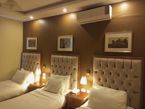 马达巴Mariam Hotel的配有2盏灯的酒店客房的2张床