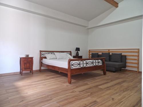 塔拉法尔Kaps Home - Tarrafal的一间卧室配有一张床、一张沙发和一把椅子