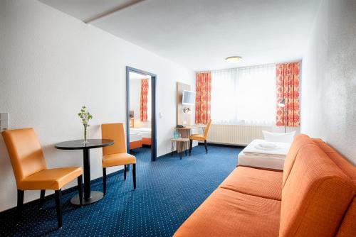 德累斯顿ACHAT Hotel Dresden Altstadt的酒店客房带一张床、一张桌子和椅子