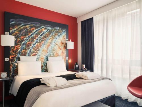 里尔里尔中心维尤克斯里尔美居酒店的酒店客房带一张大床,带毛巾