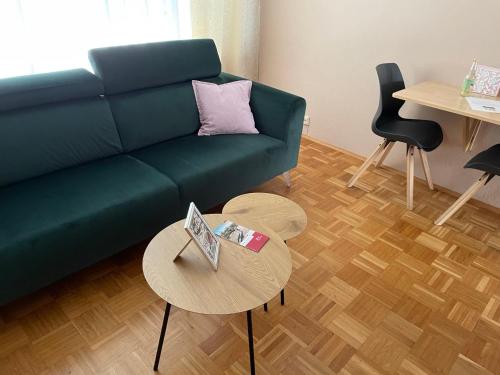 维尔茨堡维尔茨堡斯塔特米特公寓 的客厅配有绿色沙发和桌子