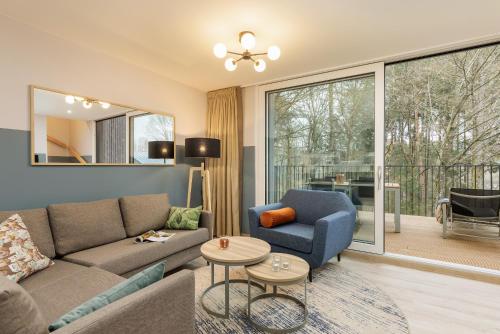 Gunderath艾弗尔茂矽纽伯格林中心公园酒店的客厅配有沙发和椅子