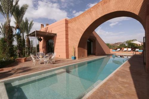 马拉喀什Villa Jolyamelkis - golf Marrakech的一座带游泳池和大楼的房子