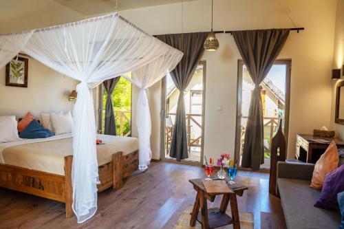 MakunduchiClove Island Villas & Spa的一间带天蓬床的卧室和一间客厅