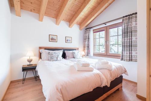 采尔马特尤莱西小木屋公寓的一间卧室设有一张大床和一个窗户。