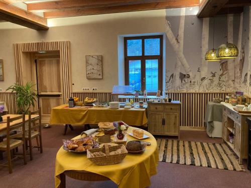 克吕特法国奥贝格酒店的厨房配有2张桌子和食物