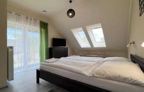 杰尔Gardencity Apartmanház的一间卧室设有一张大床和两个窗户