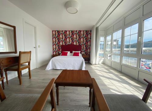 穆罗斯杰.拉戈旅馆的卧室配有一张床、一张书桌和窗户。