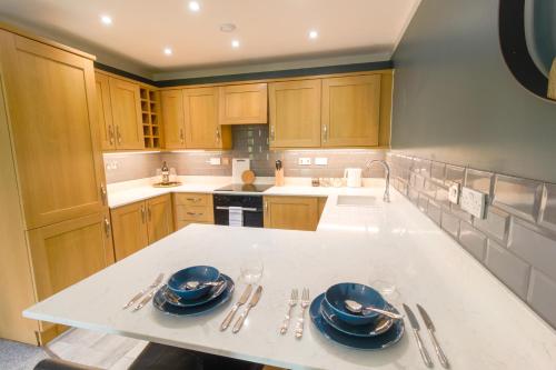 布由德利Luxury Apartments - MBS Lettings的厨房配有木制橱柜和柜台上的蓝色菜肴