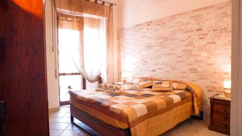 阿尔盖罗PM 12 Via Achille Grandi Guest House的一间卧室配有一张砖墙床