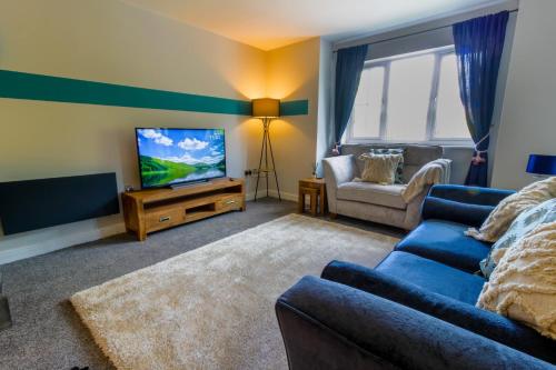 布由德利Luxury Apartments - MBS Lettings的客厅配有蓝色的沙发和电视