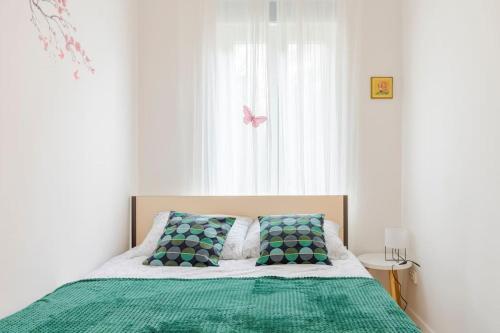 萨格勒布Petrova street的一张带绿毯的床和窗户上的粉红色蝴蝶