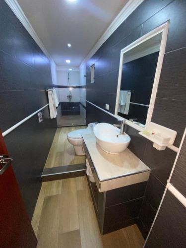博卡奇卡Hotel Vicentina的一间带水槽和镜子的浴室以及两个卫生间