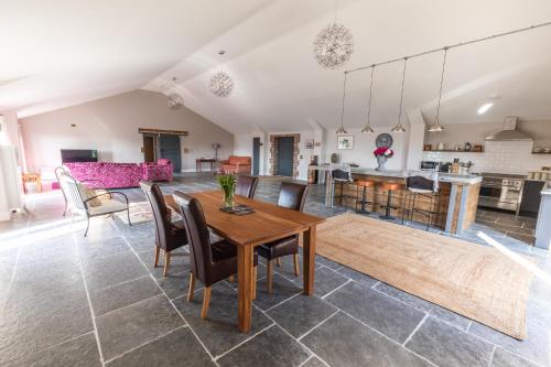 吉尔斯菲尔德Gaer Fawr Barns的客厅以及带木桌和椅子的厨房。