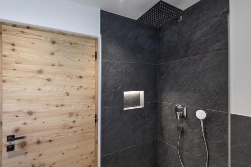 奥蒂塞伊Chalet Berna的带淋浴的浴室和木墙