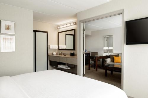 奥兰多奥兰多机场喜来登套房酒店的酒店客房,配有床和镜子