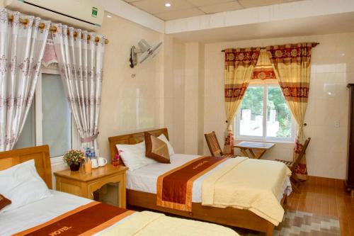 峰牙HOA PHUONG PHONG NHA Hotel的一间卧室设有两张床和窗户。