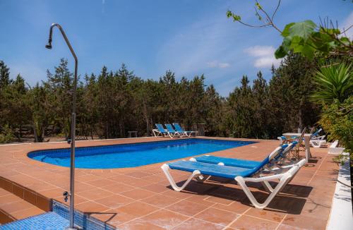米乔尔海滩Siamoformentera Villa Beatrice的一个带躺椅的游泳池和蓝色的游泳池