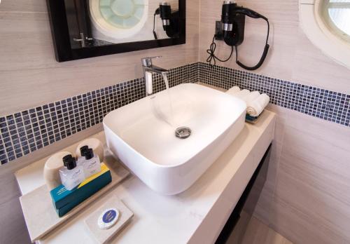广宁Minh Chau Pearl Hotel & Spa - Quan Lan Island的浴室设有白色水槽和镜子